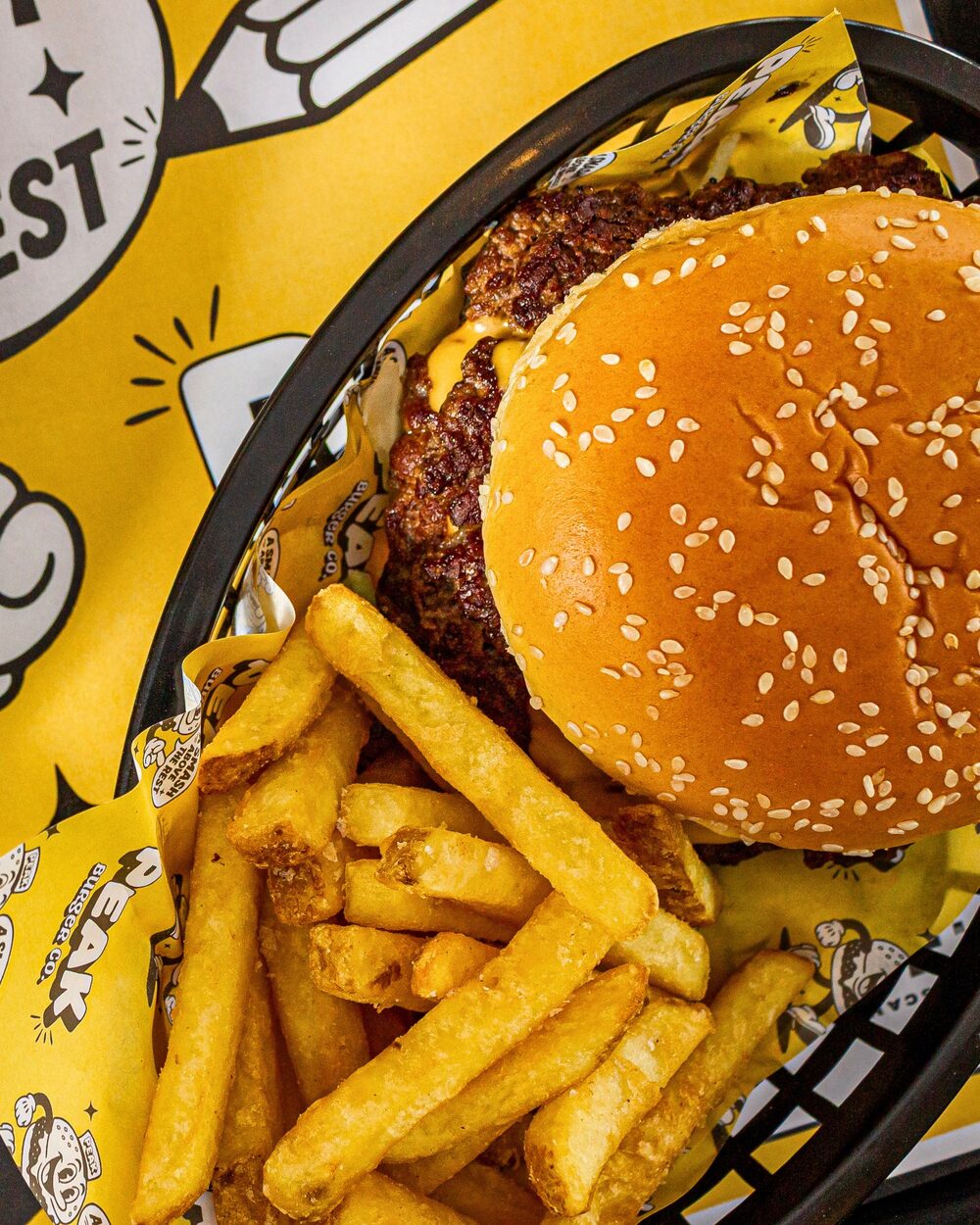 Smash beef burger with crispy fries in a Peak Burger Co basket