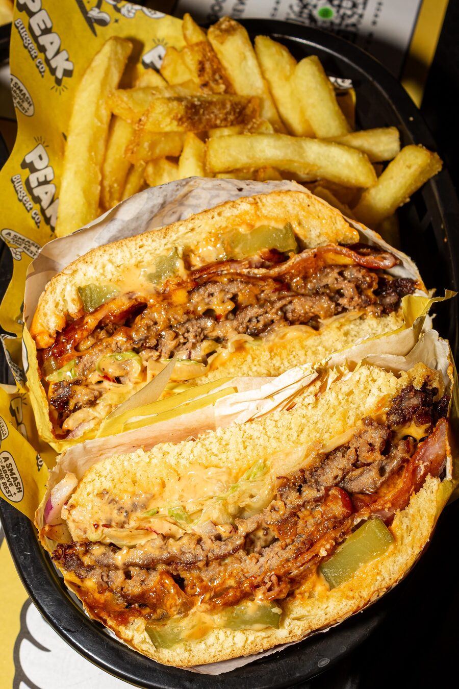 Cross-section of a loaded Peak Burger Co smash burger with chunky fries